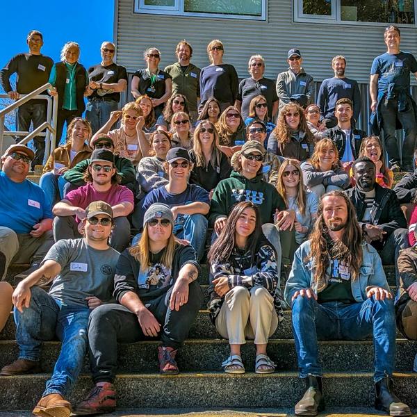Students and instructors sitting on steps in front of a building