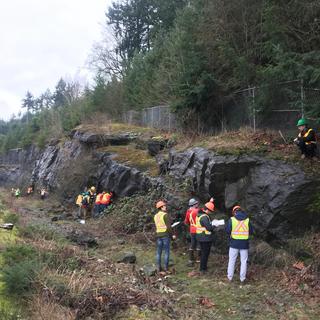 Students learning to take structural measurements and make geological observations at Malaspina Cut