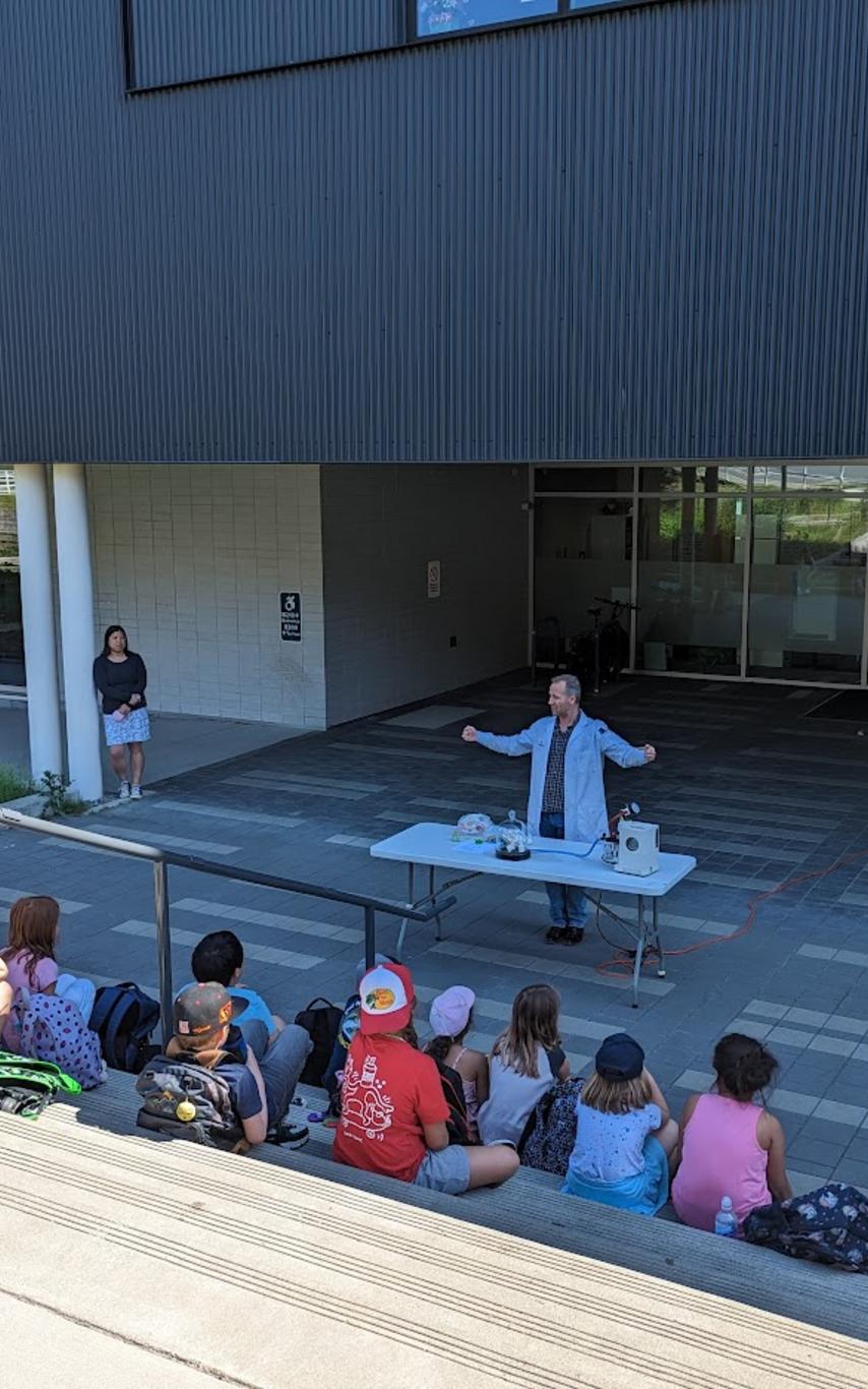 Children sitting on stairs watching chemistry show
